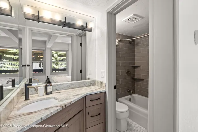 a bathroom with a granite countertop sink toilet and shower