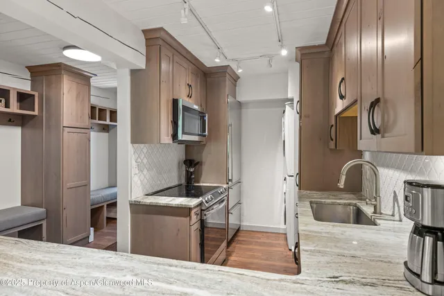 a kitchen with stainless steel appliances granite countertop a refrigerator and a sink