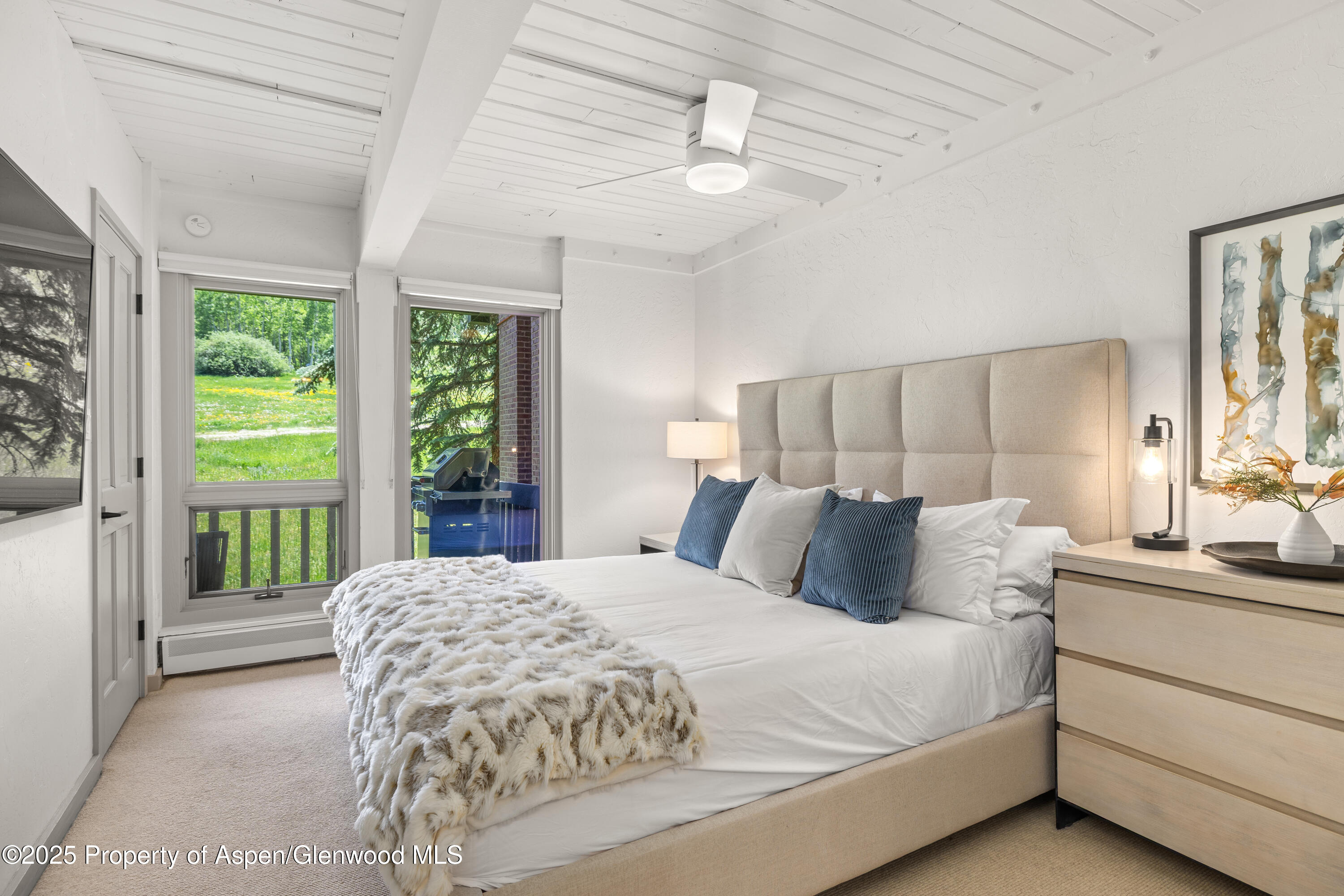 70 Gallun Lane, Unit 206B Snowmass Village, CO 81615 - Photo 10 of 15 a bedroom with a large bed and a chandelier