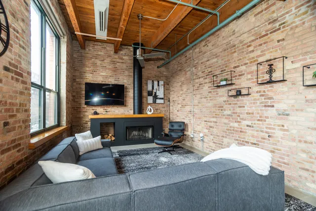 a living room with furniture a flat screen tv and a fireplace