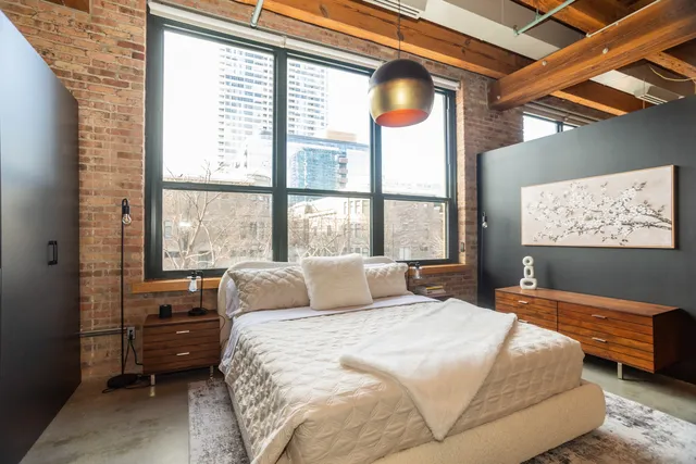 a bedroom with a bed and a large window