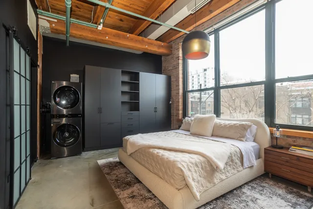 a bedroom with a bed and a large window