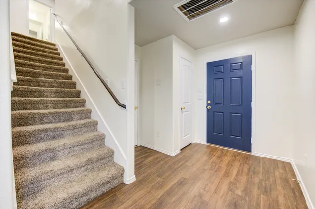 a view of an empty room with a chandelier fan