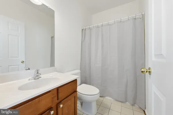 a bathroom with a sink a toilet and shower curtain