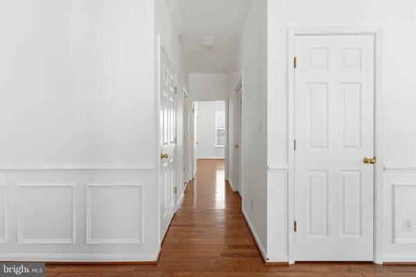 a view of a hallway with wooden floor and entryway