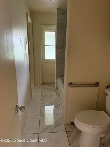 a bathroom with a toilet and a shower