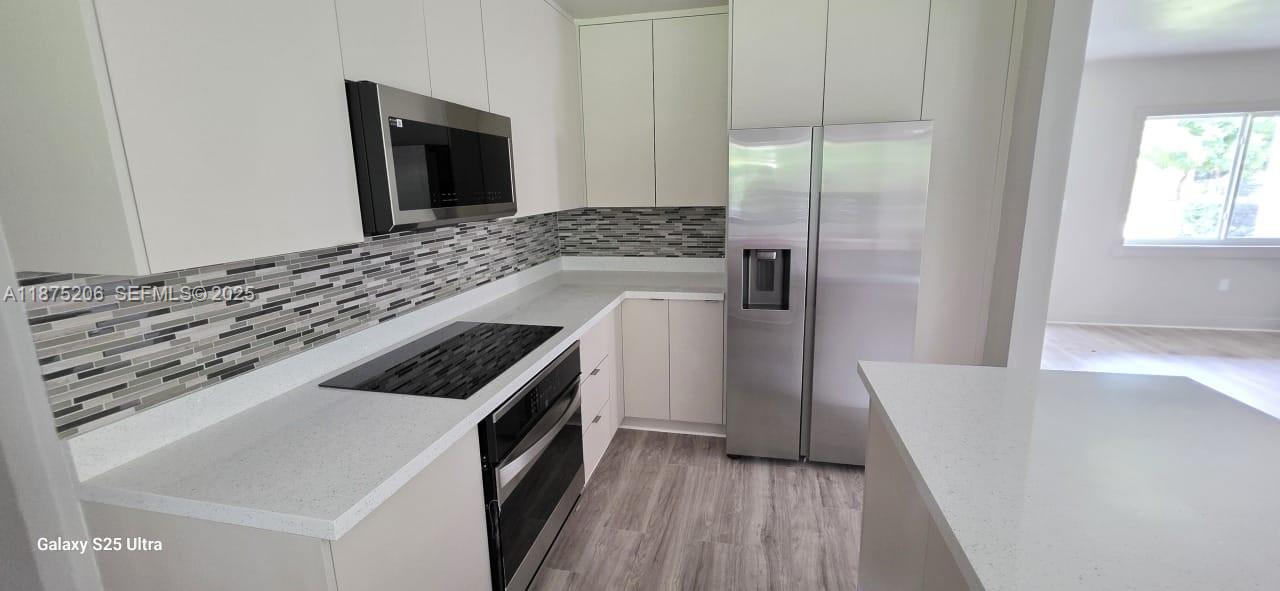 1340 Northwest 133rd Street Miami, FL 33167 - Photo 6 of 31 a kitchen with a stove and a refrigerator