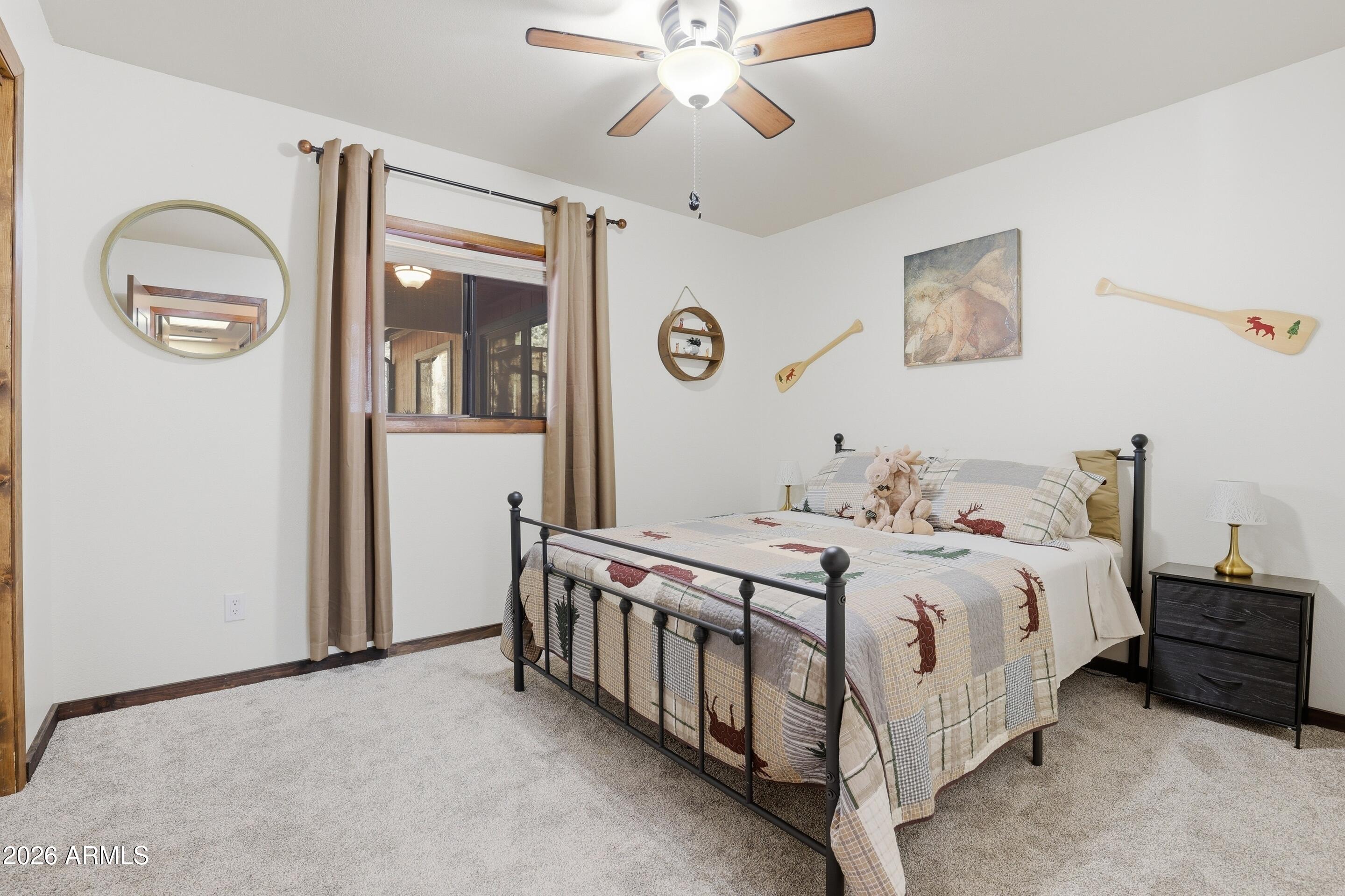 6740 Ridge Road Pine, AZ 85544 - Photo 16 of 35 a bedroom with a bed and a chandelier