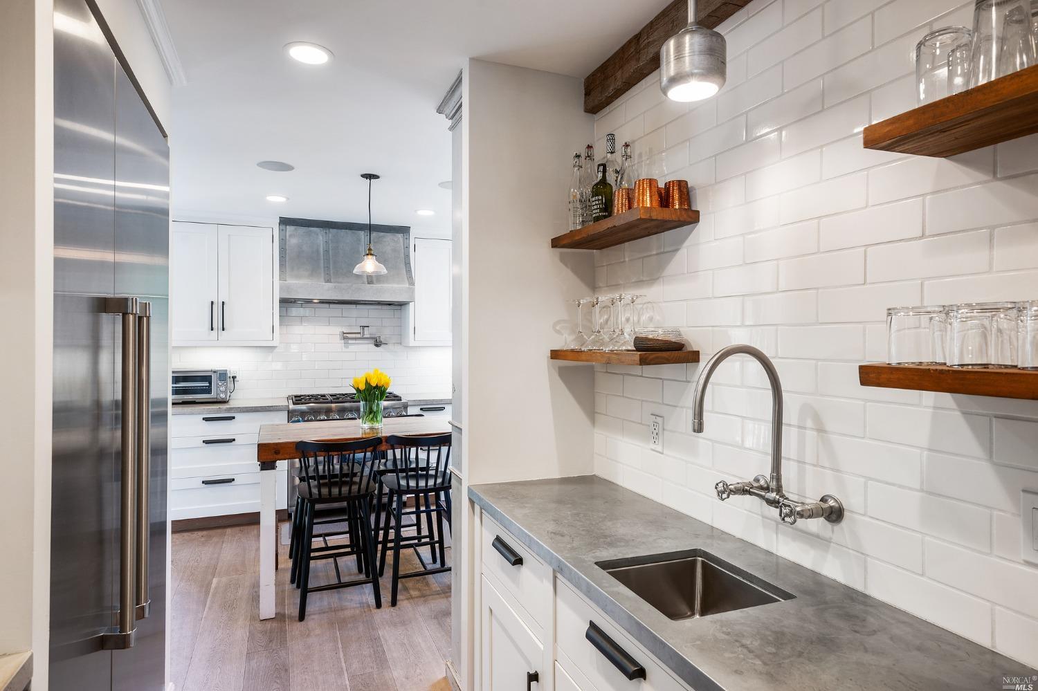 16 Hill Street Mill Valley, CA 94941 - Photo 20 of 55 a kitchen with stainless steel appliances kitchen island a table and chairs in it