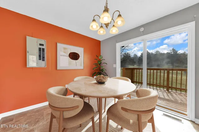 a dining room with furniture and a floor to ceiling window