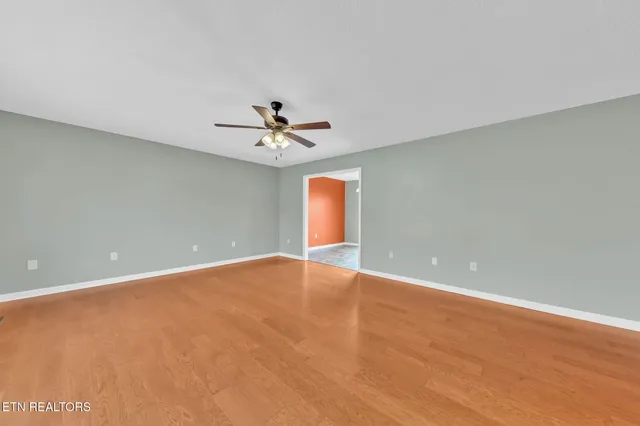 a view of an empty room with a chandelier fan