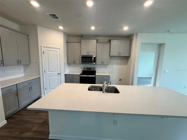 a kitchen with kitchen island a stove a sink and refrigerator