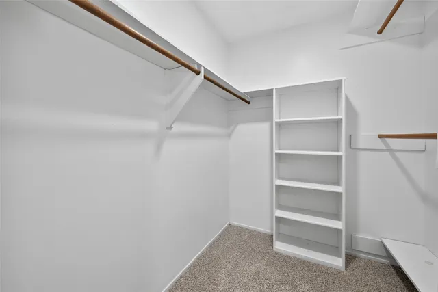 a view of walk in closet with empty racks