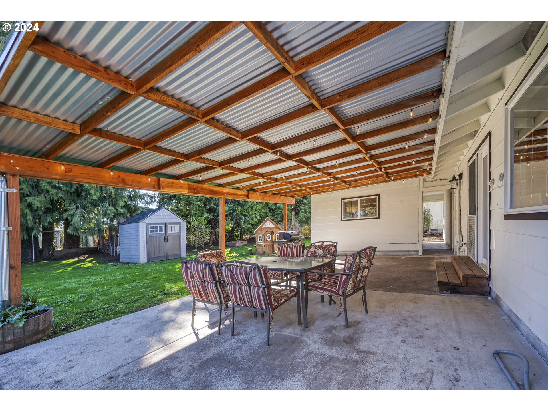 1127 South 34th Place Springfield, OR 97478 - Photo 33 of 40 a view of a backyard with table and chairs with a barbeque grill with plants and large trees