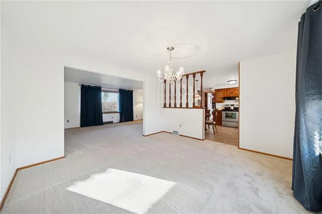 a view of an empty room with stairs and a window