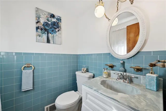 a bathroom with a toilet a sink and mirror