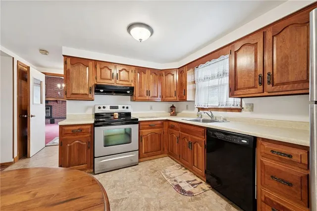 a kitchen with stainless steel appliances granite countertop a stove sink and cabinets