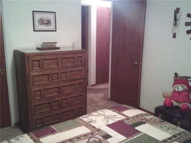 a bedroom with a bed and a dresser in it