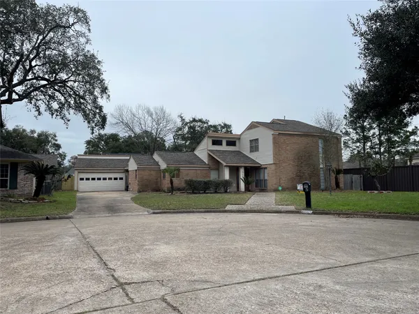 a view of house with a yard and large tree