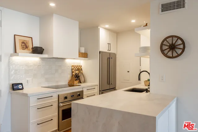 a kitchen with a refrigerator and a stove top oven