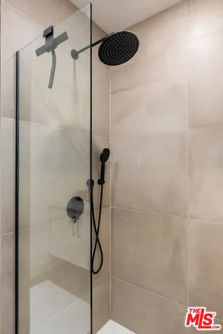 a spacious bedroom with a bed and chair