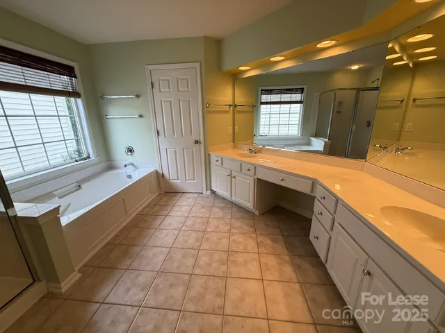 a large bathroom with a large tub sink and mirror