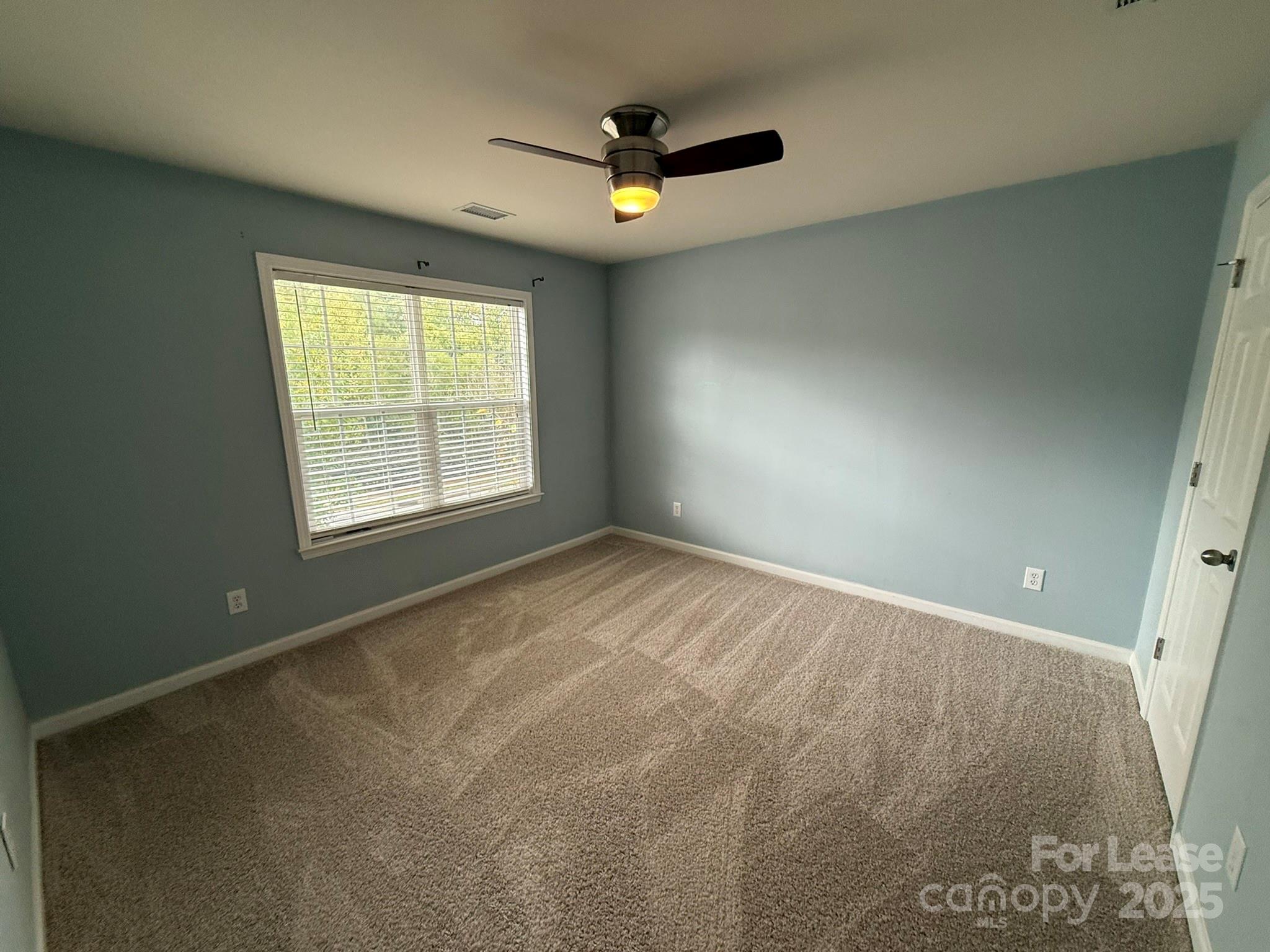 10431 Olde Ivy Way Charlotte, NC 28262 - Photo 19 of 24 an empty room with ceiling fan and windows