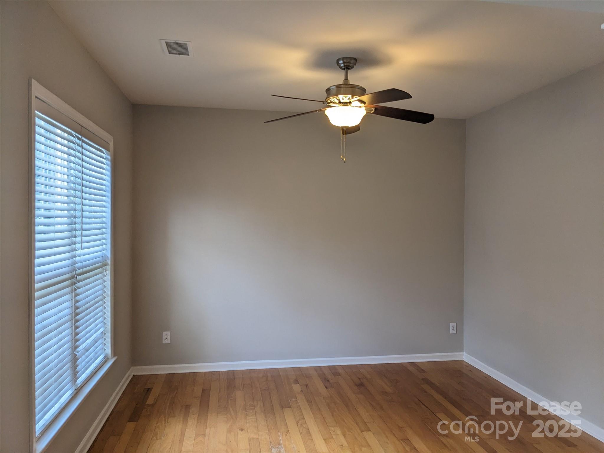 10431 Olde Ivy Way Charlotte, NC 28262 - Photo 2 of 24 an empty room with wooden floor and windows
