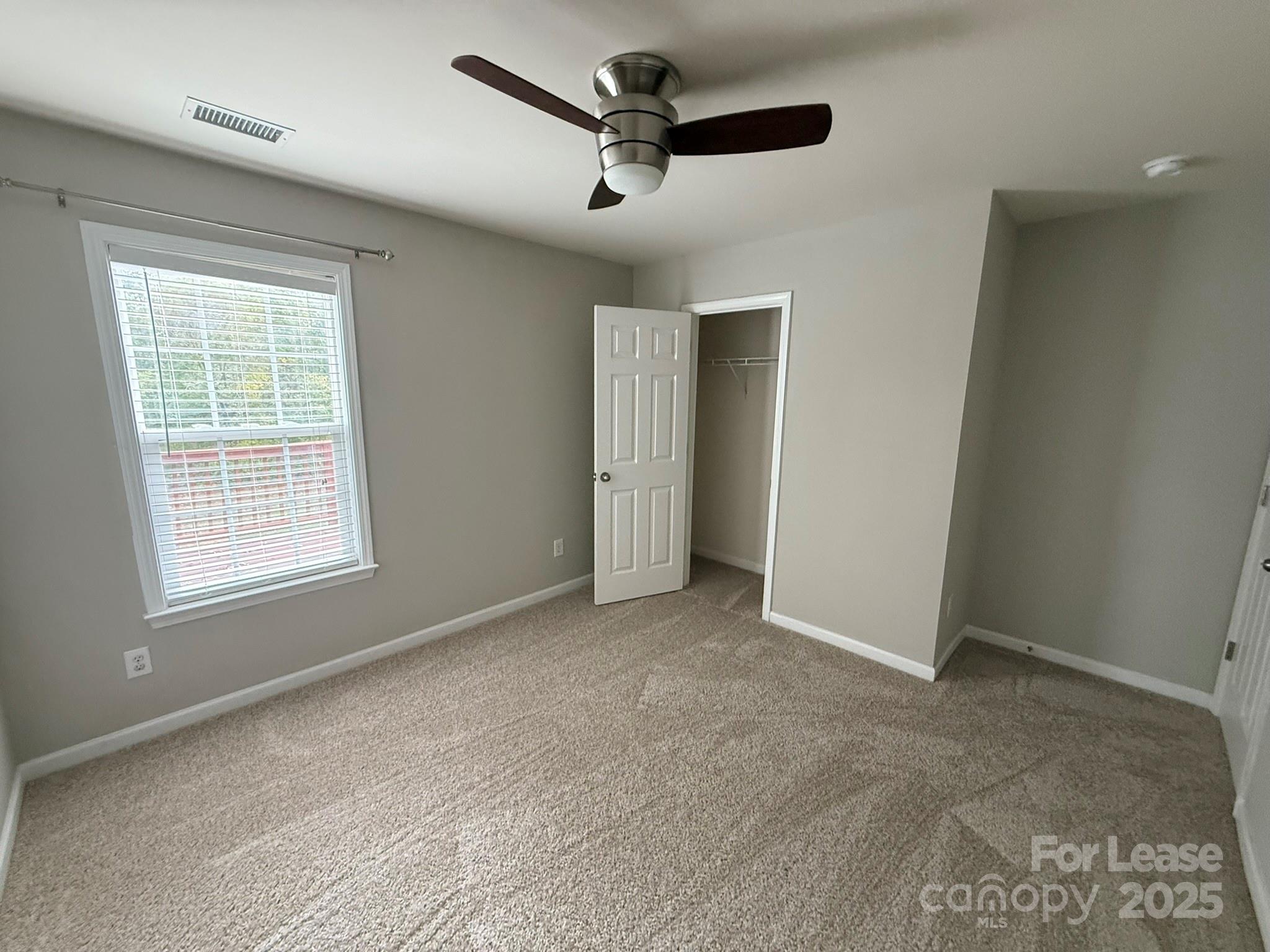 10431 Olde Ivy Way Charlotte, NC 28262 - Photo 23 of 24 an empty room with windows and ceiling fan