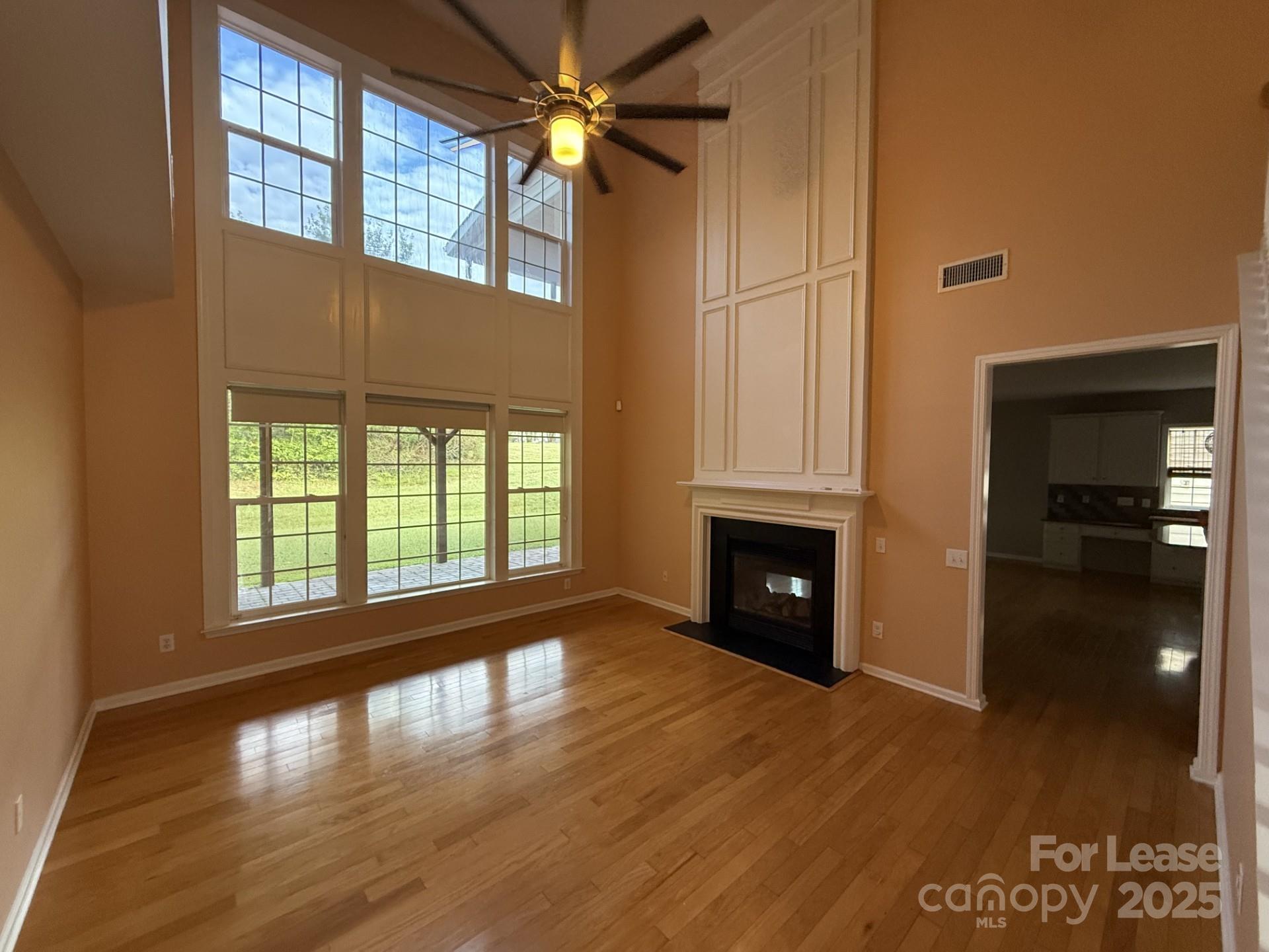 10431 Olde Ivy Way Charlotte, NC 28262 - Photo 7 of 24 a view of a livingroom with wooden floor a fireplace and windows