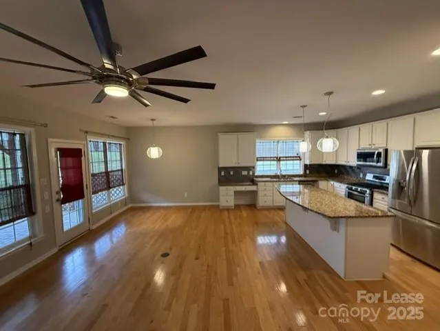 a large kitchen with stainless steel appliances granite countertop a large counter top and a stove