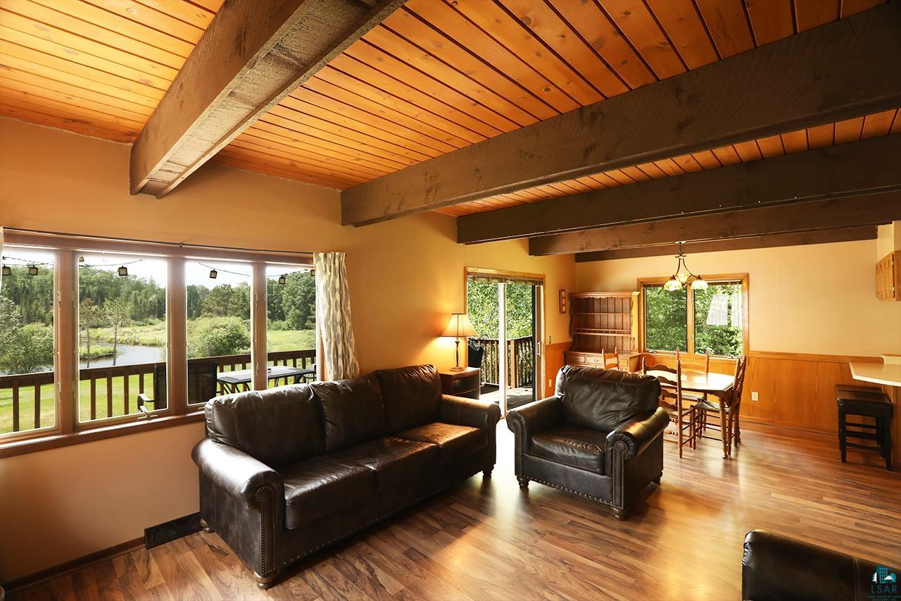 9289 Heino Road Angora, MN 55703 - Photo 2 of 37 Expansive living area featuring a wood-finish floor and exposed wood beam ceiling