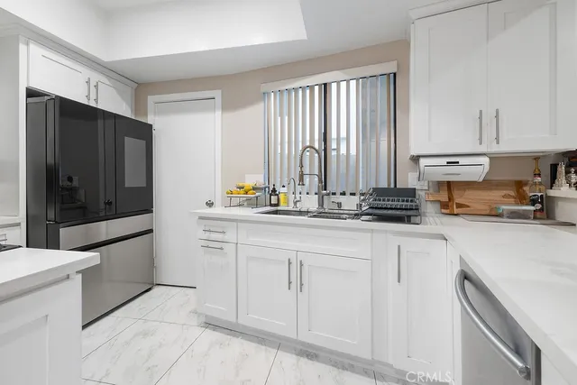 a kitchen with stainless steel appliances a refrigerator sink and cabinets
