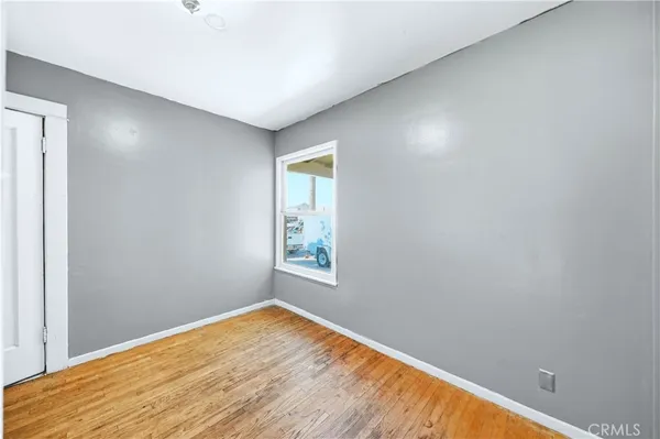 a view of empty room with wooden floor