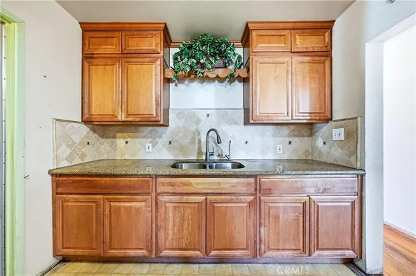 a kitchen with granite countertop wooden cabinets a sink and dishwasher