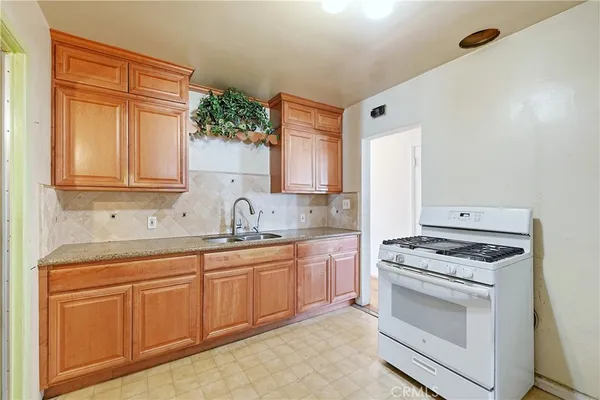 a kitchen with granite countertop a sink stainless steel appliances and cabinets