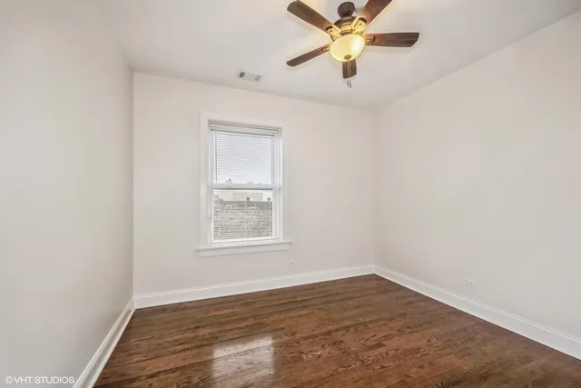an empty room with a window and a fan