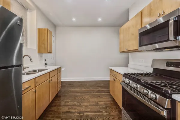a kitchen with stainless steel appliances a stove microwave and sink