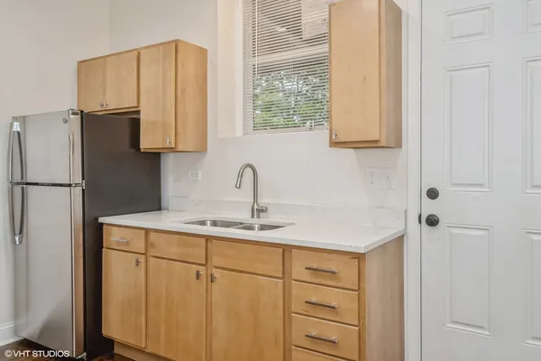 a kitchen with a sink cabinets and a refrigerator