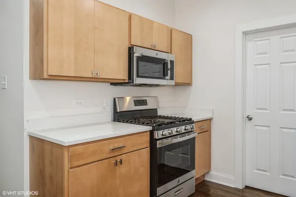 a kitchen with stainless steel appliances granite countertop white cabinets and a stove top oven