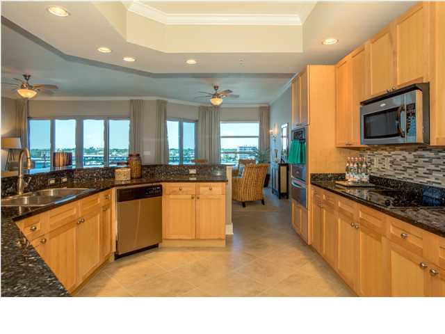 211 Durango Road, Unit 713 Destin, FL 32541 - Photo 8 of 30 a kitchen with stainless steel appliances kitchen island granite countertop a stove top oven a sink dishwasher a dining table and chairs