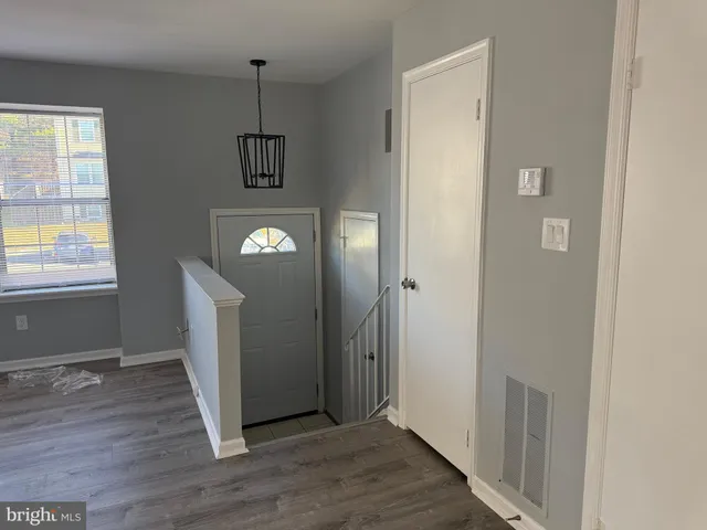 an entryway at room with wooden floor and windows