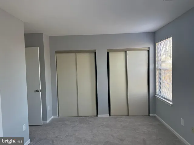 an empty room with windows and closet