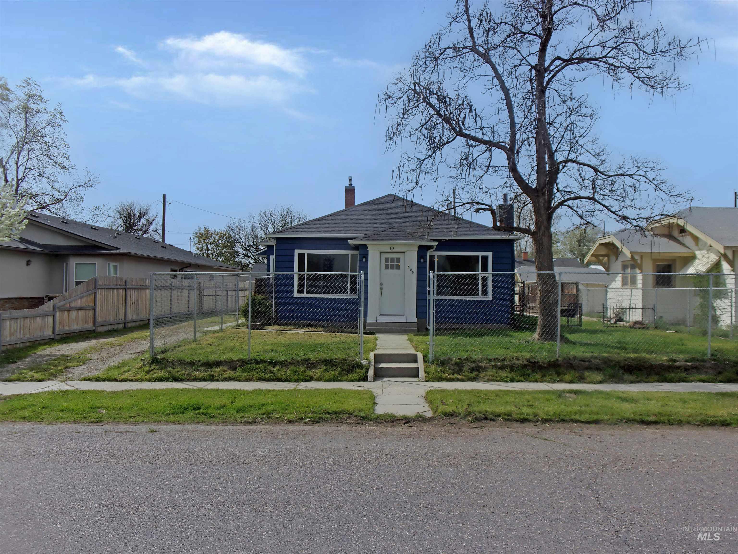 View of front of property featuring a chimney and a fenced front yard