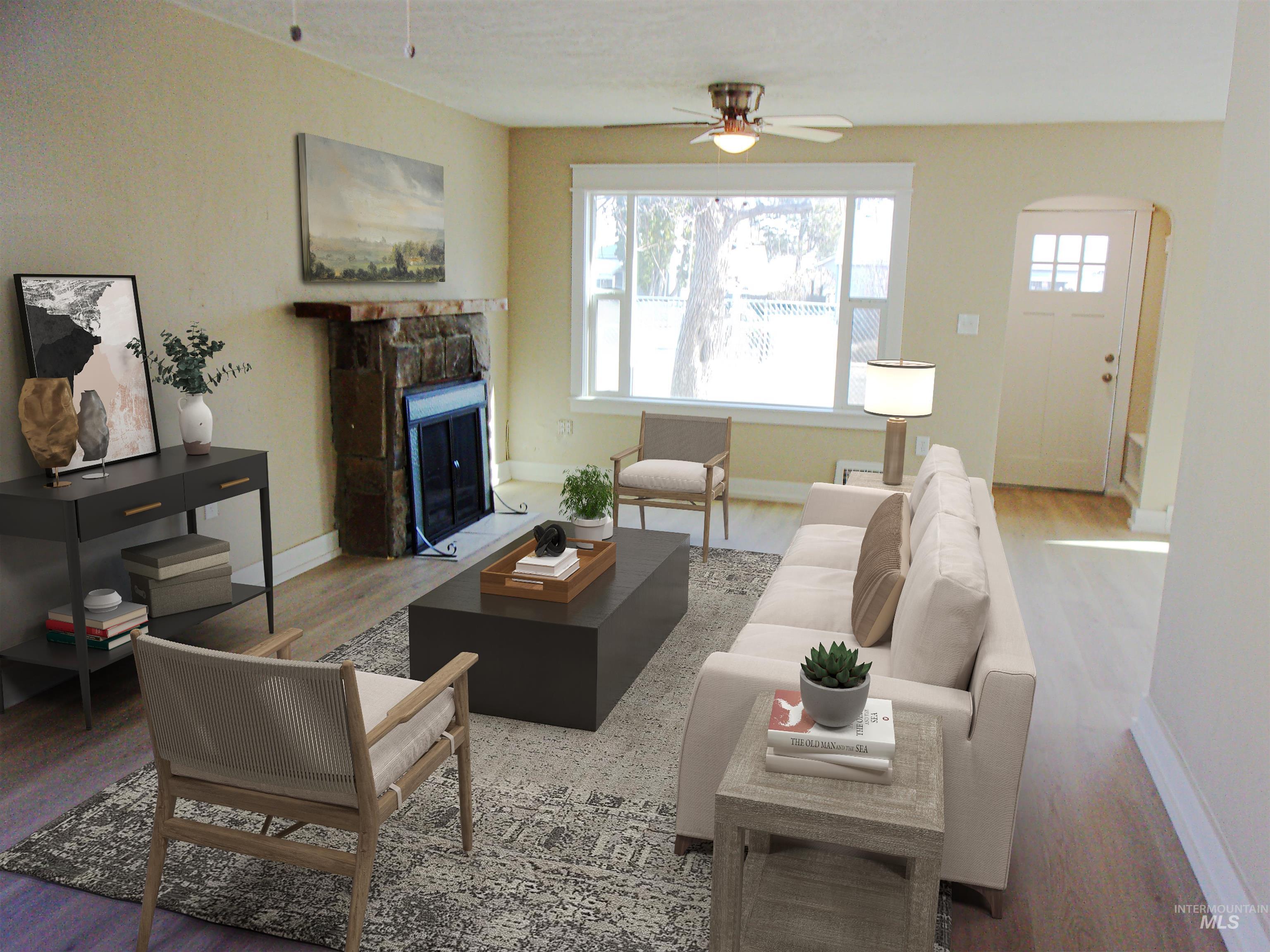 605 North 6th Street Parma, ID 83660 - Photo 11 of 46 Living area with wood finished floors, a fireplace, arched walkways, and ceiling fan