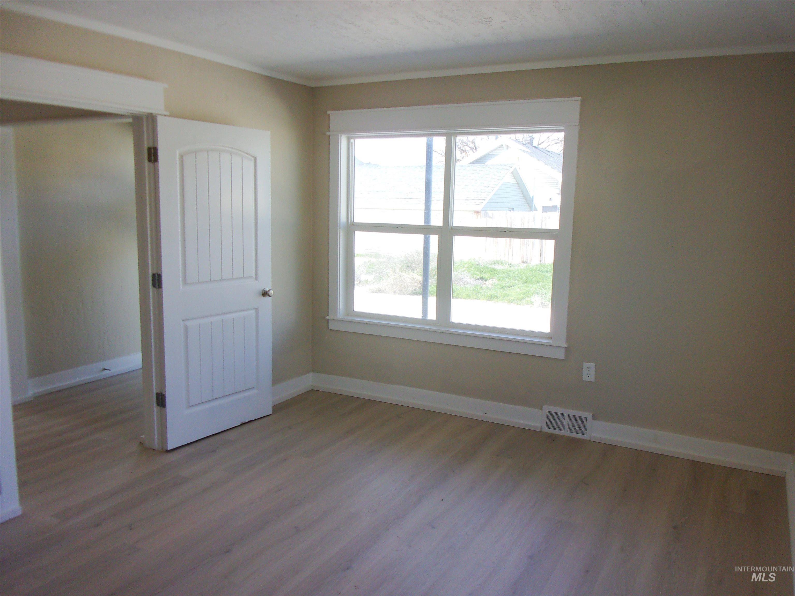 605 North 6th Street Parma, ID 83660 - Photo 14 of 46 Spare room featuring wood finished floors and ornamental molding
