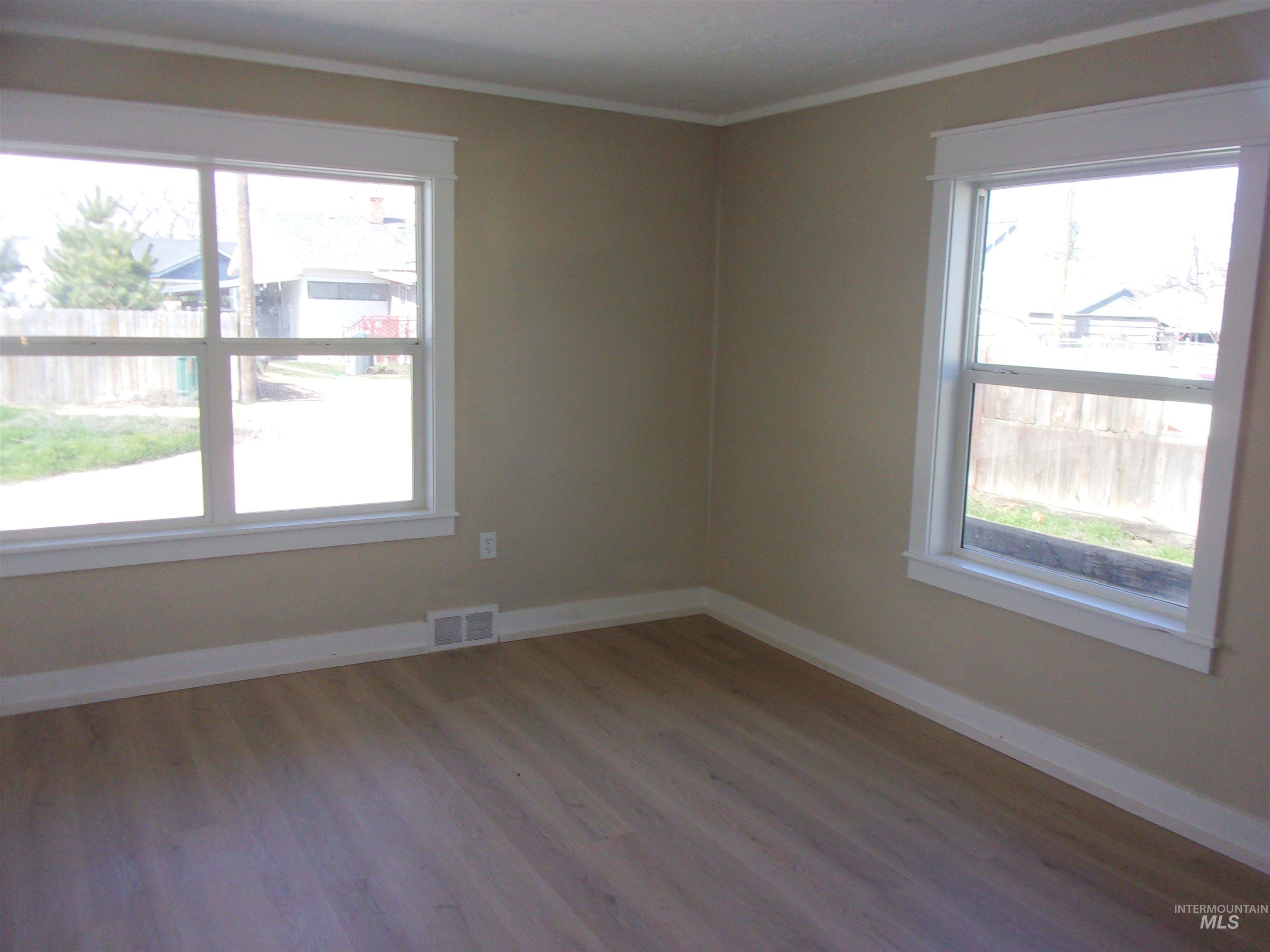 605 North 6th Street Parma, ID 83660 - Photo 15 of 46 Spare room featuring wood finished floors, healthy amount of natural light, and crown molding