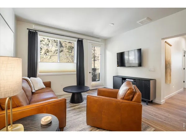 a kitchen with stainless steel appliances kitchen island granite countertop a stove top oven a sink dishwasher a dining table and chairs with wooden floor