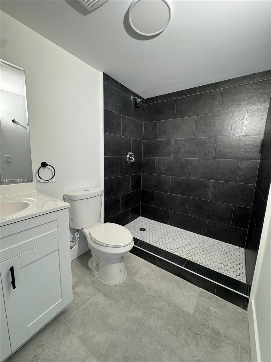 147 Northwest 59th Street, Unit 303 Miami, FL 33127 - Photo 10 of 13 a bathroom with a toilet a sink and shower