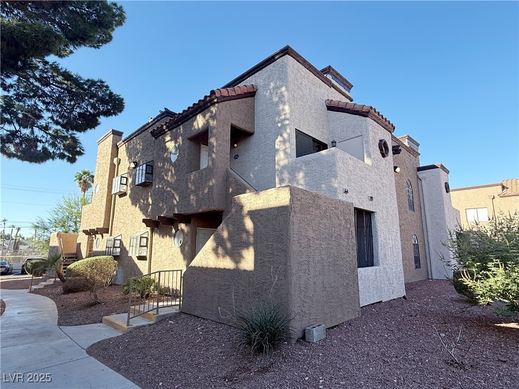 2981 Juniper Hills Boulevard, Unit 204 Las Vegas, NV 89142 - Photo 1 of 17 View of property exterior featuring stucco siding, a tiled roof, and a balcony